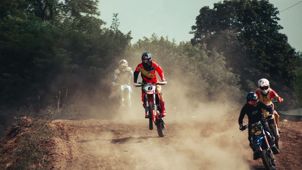 A rider on an off-road motorcycle throwing dust on a trail