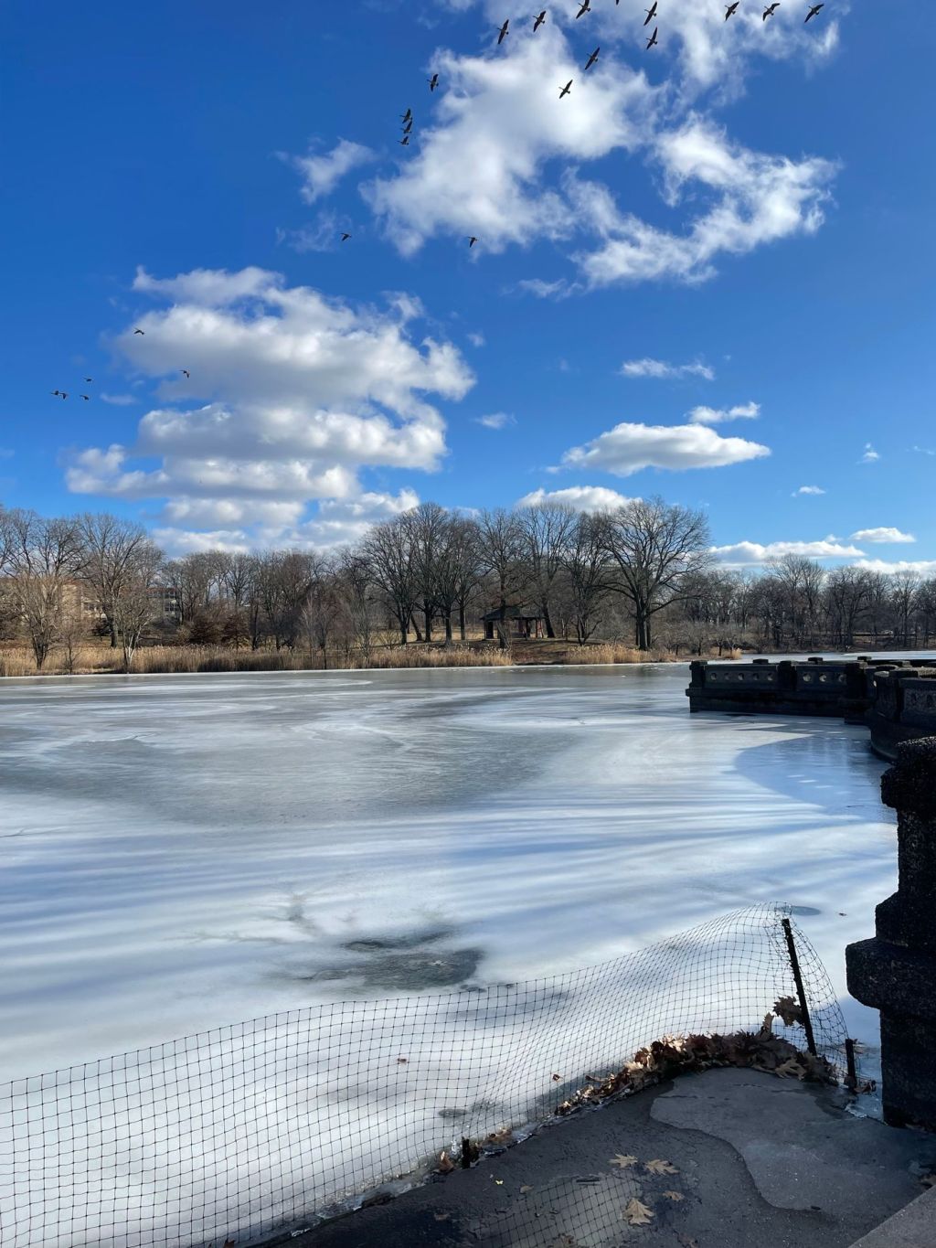 A partly frozen lake under a bright sky