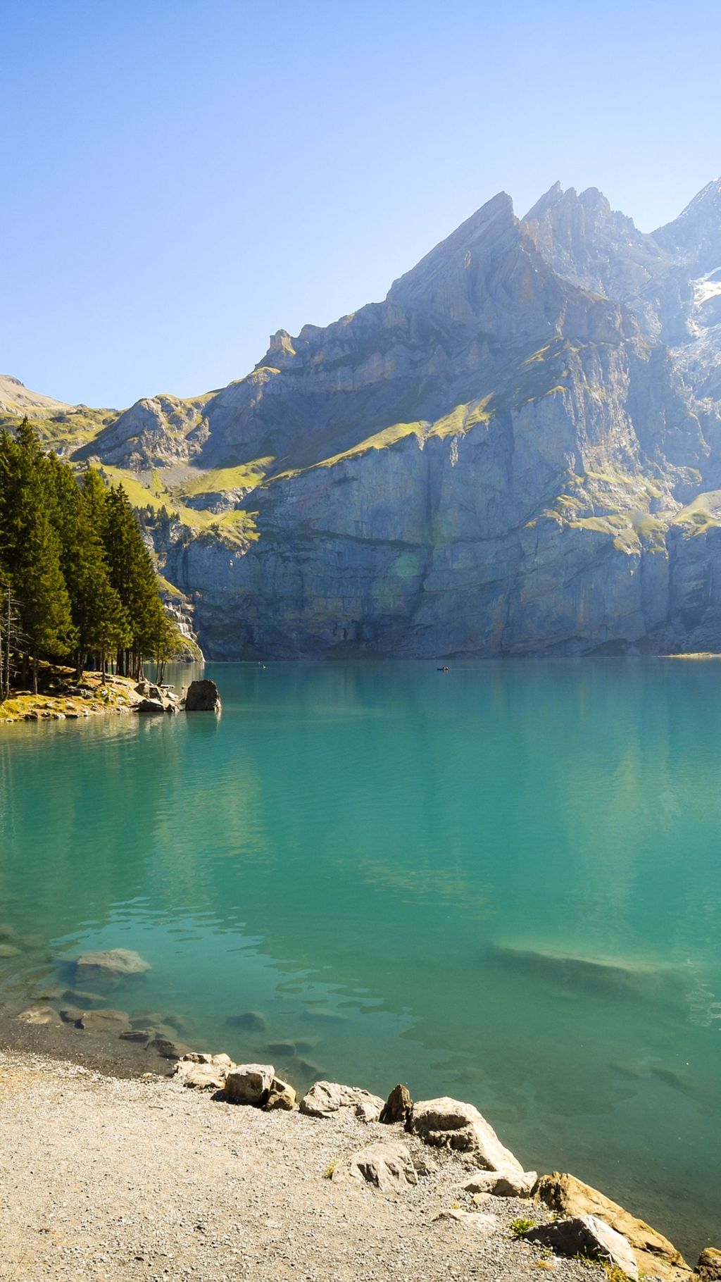 A clear mountain lake below steep slopes