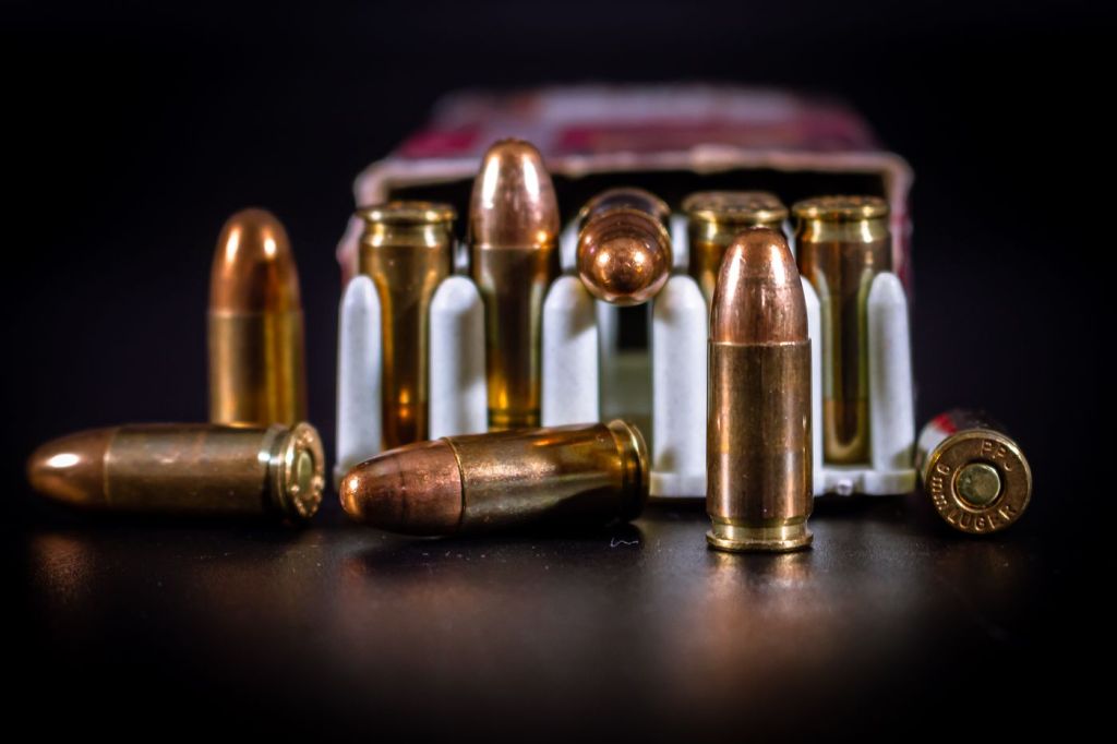 Rifle and pistol cartridges arranged on a dark surface