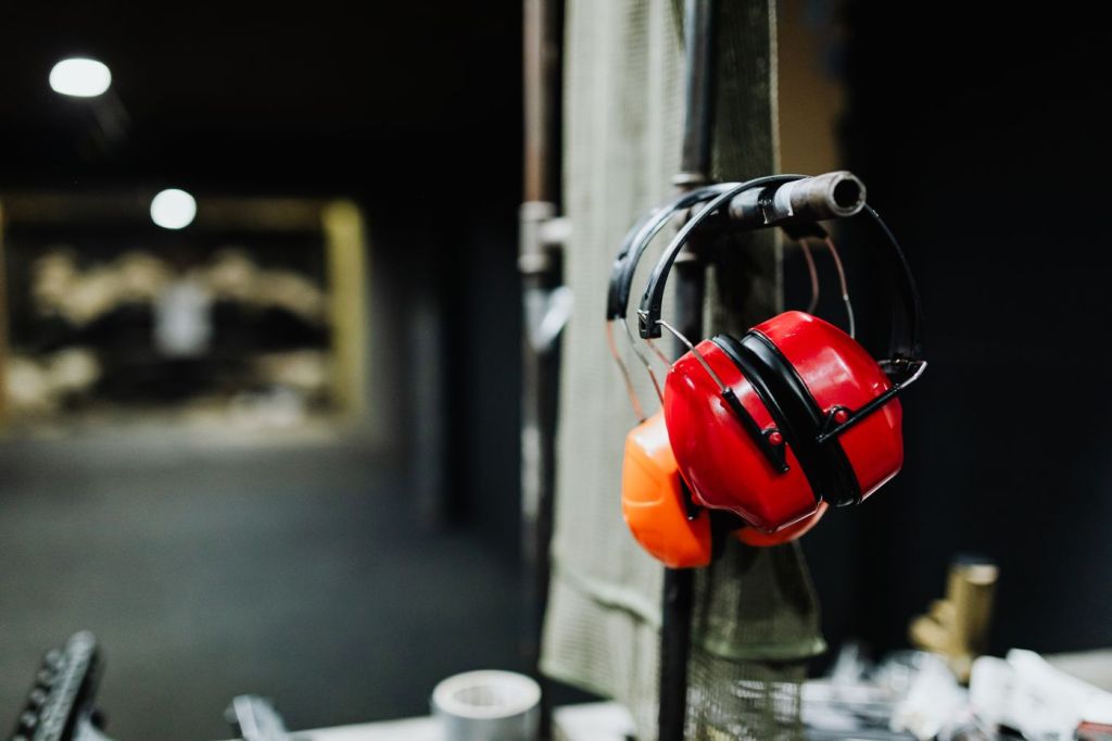 Red ear defenders hanging on a hook at an indoor shooting range