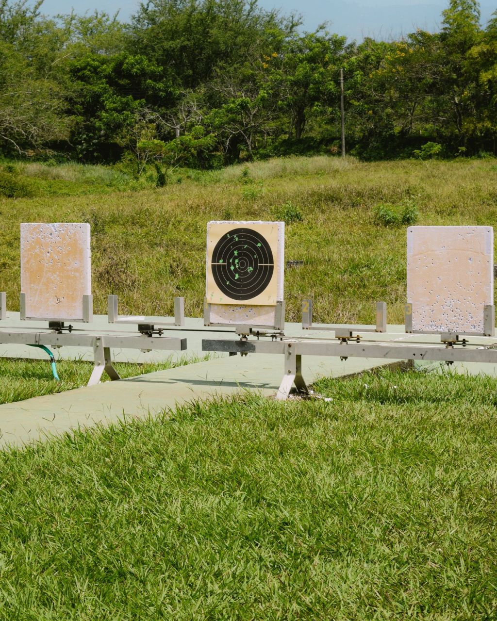 An outdoor shooting range with target boards set up on a grassy field