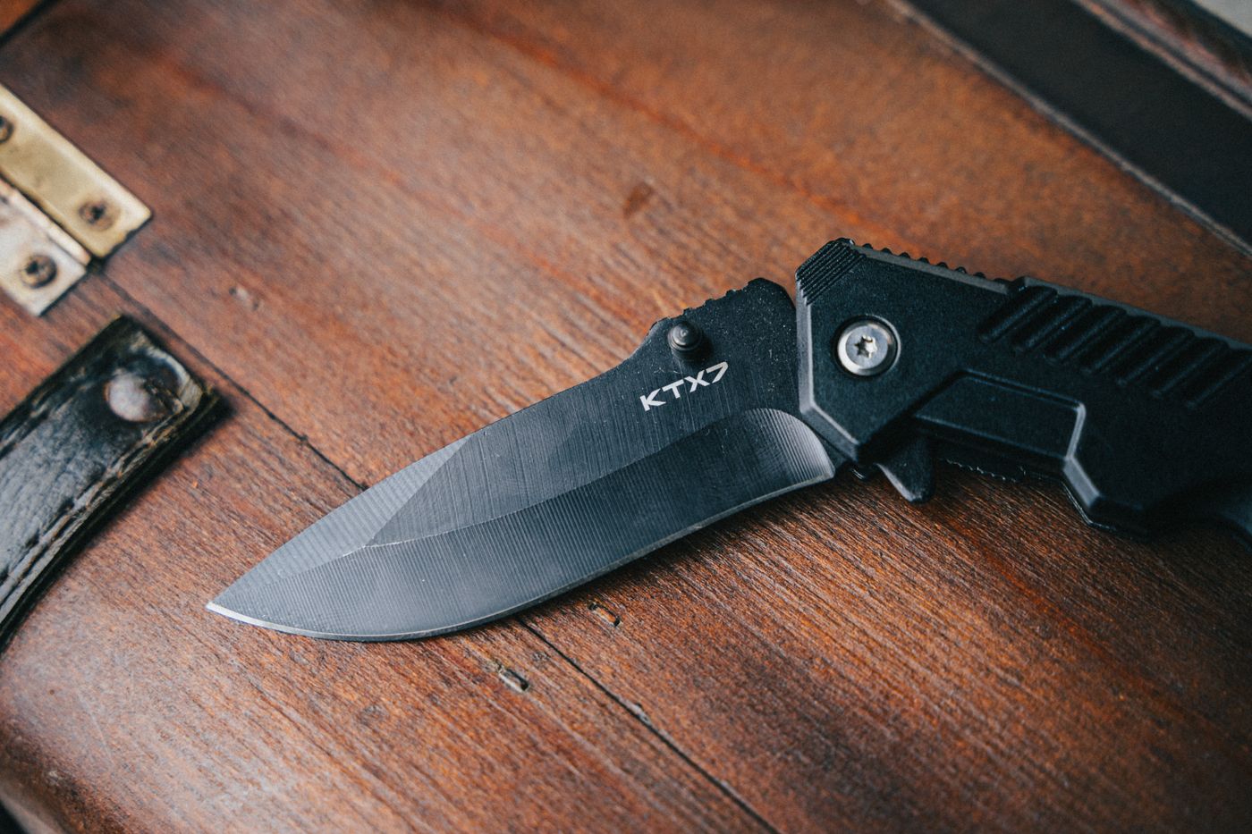 A black folding knife open on a wooden surface