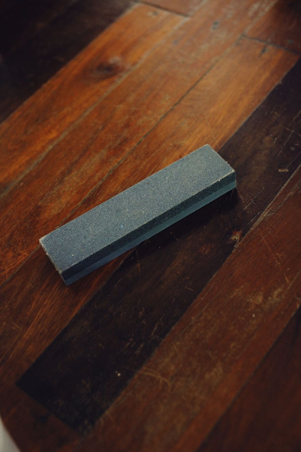 A dark sharpening stone on a plain surface