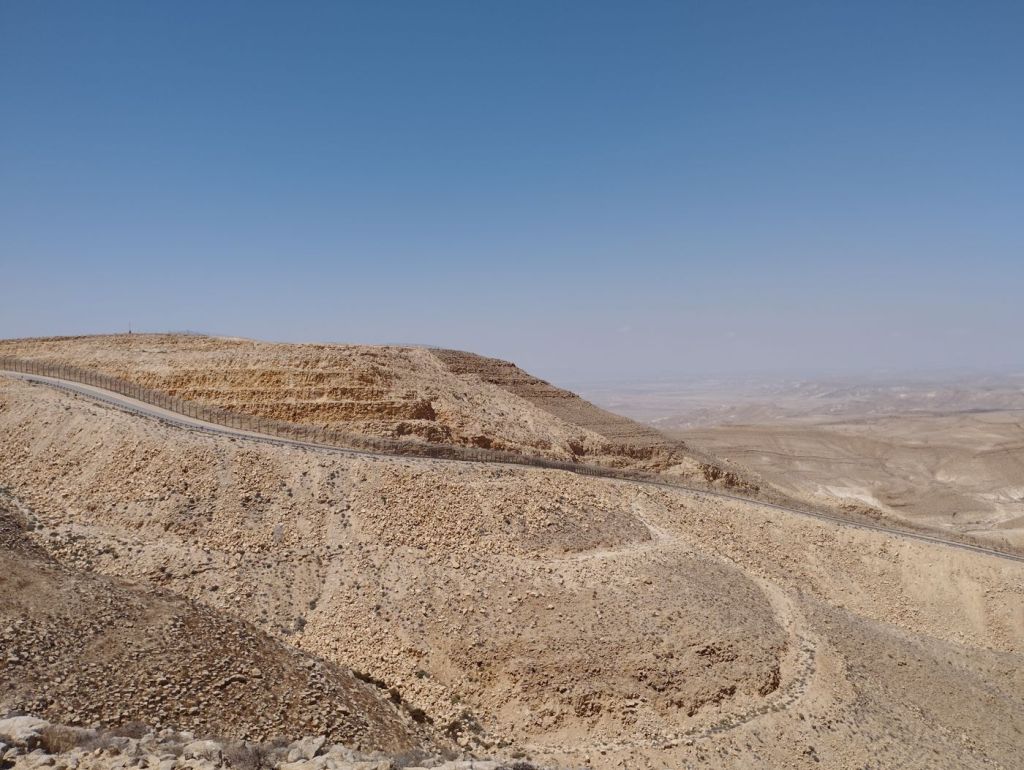 A dirt route cut across open desert terrain