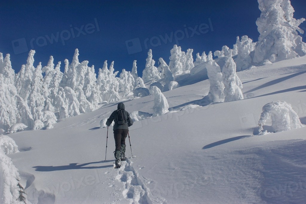 A snowshoer climbing toward a summit in winter