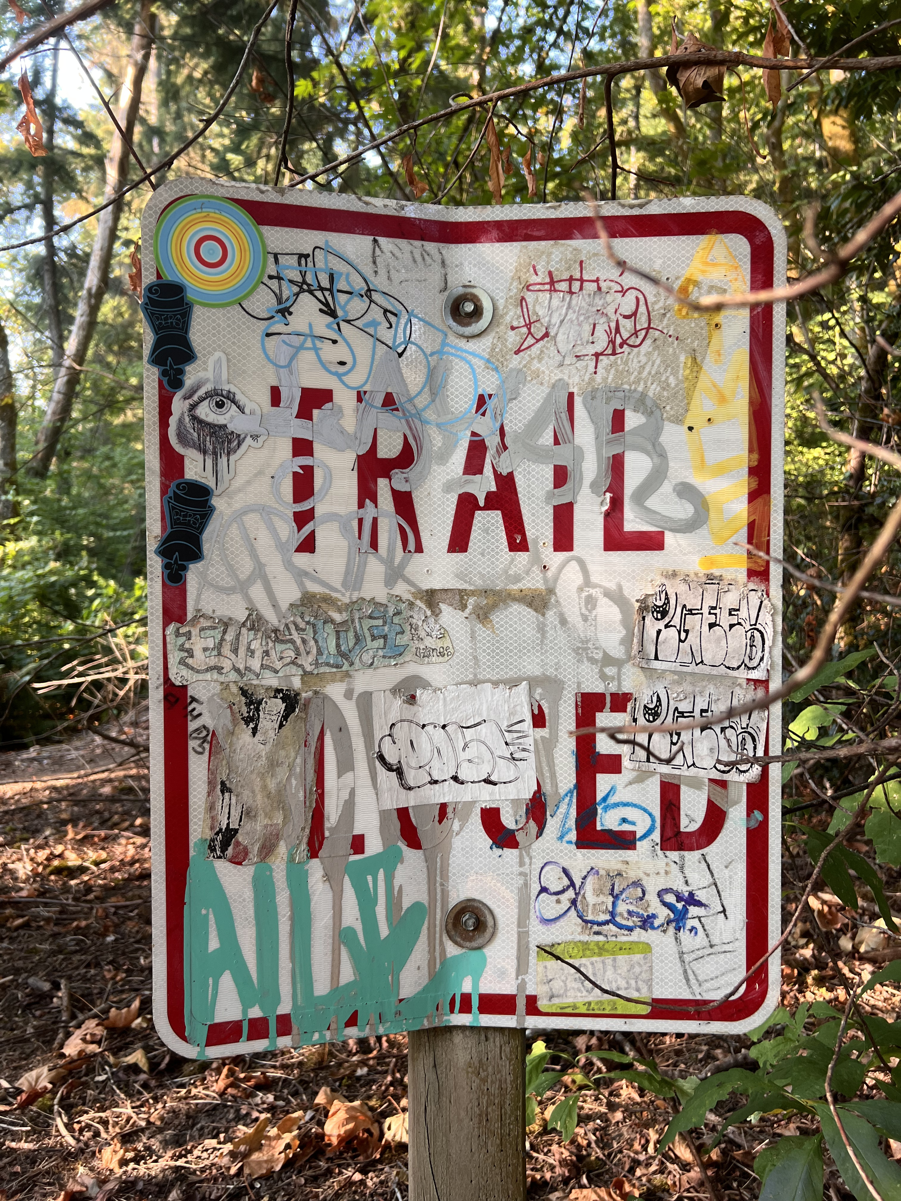 A trail closed sign blocking a path