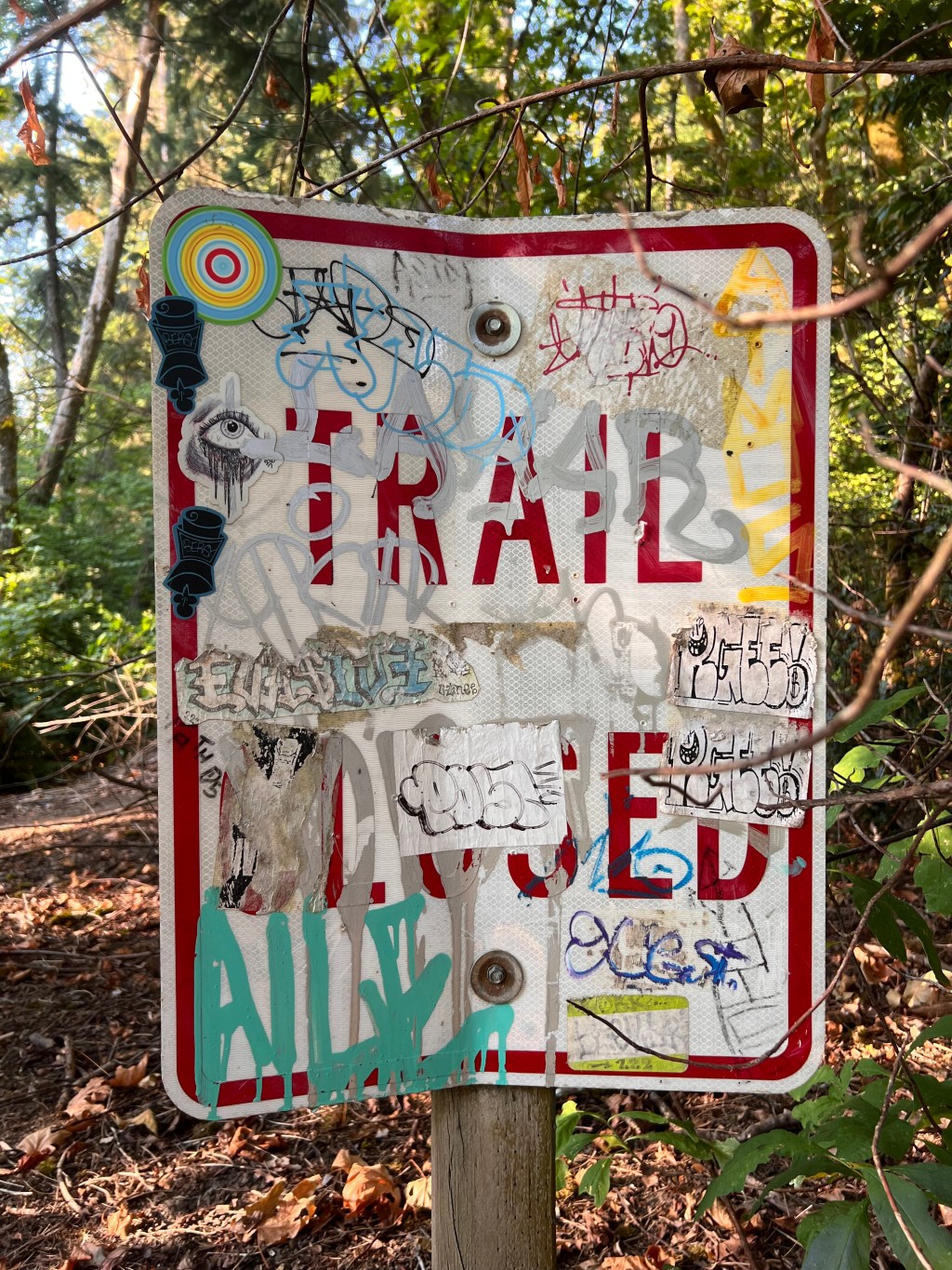 A trail closed sign blocking a path