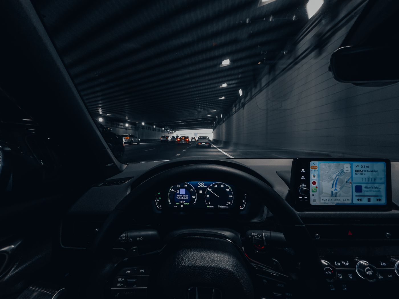 A lit vehicle dashboard seen while driving through a tunnel