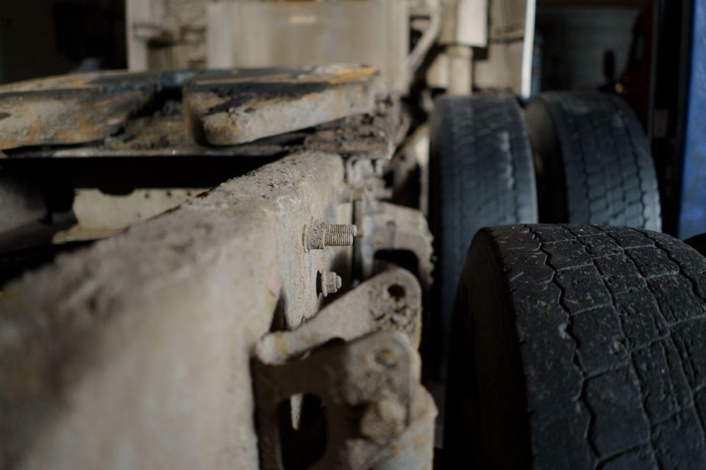 The muddy underside and axle of a heavy vehicle