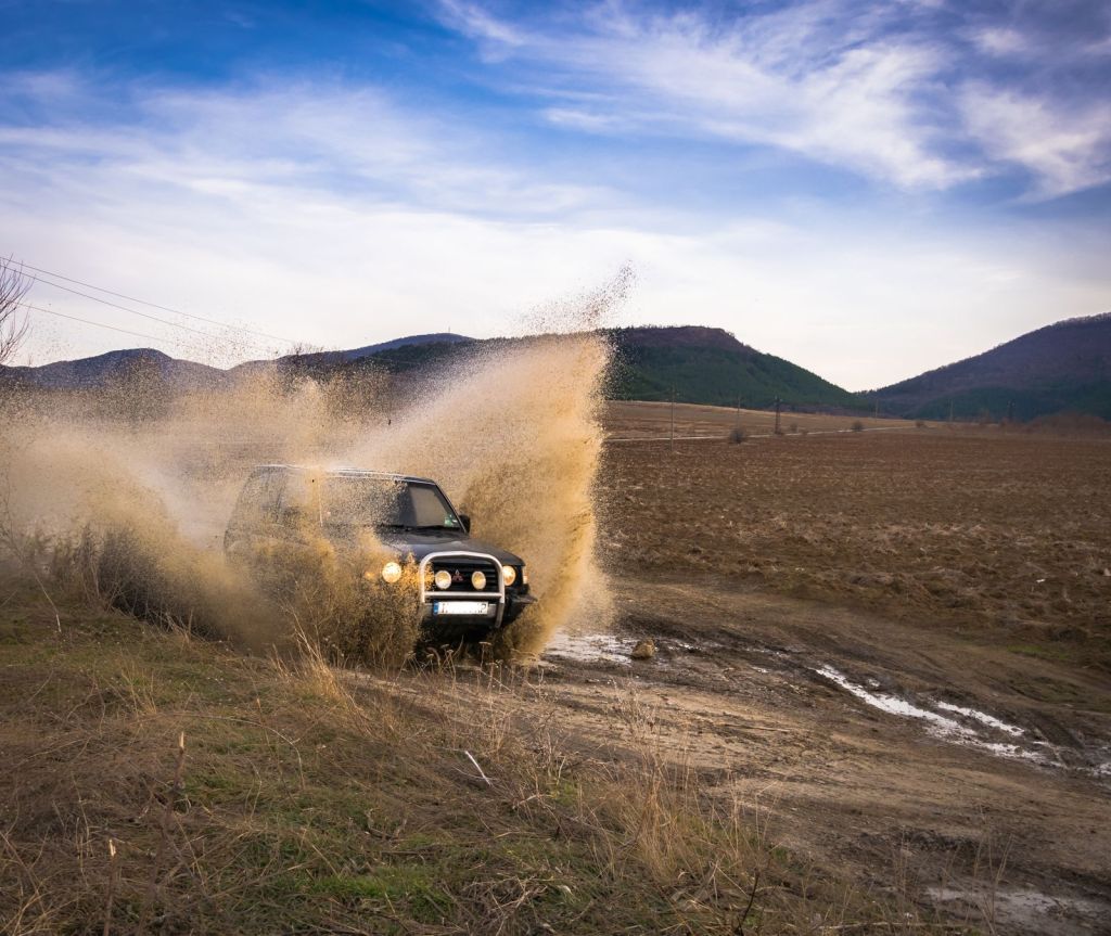 An off-road vehicle raising dust on a dirt track