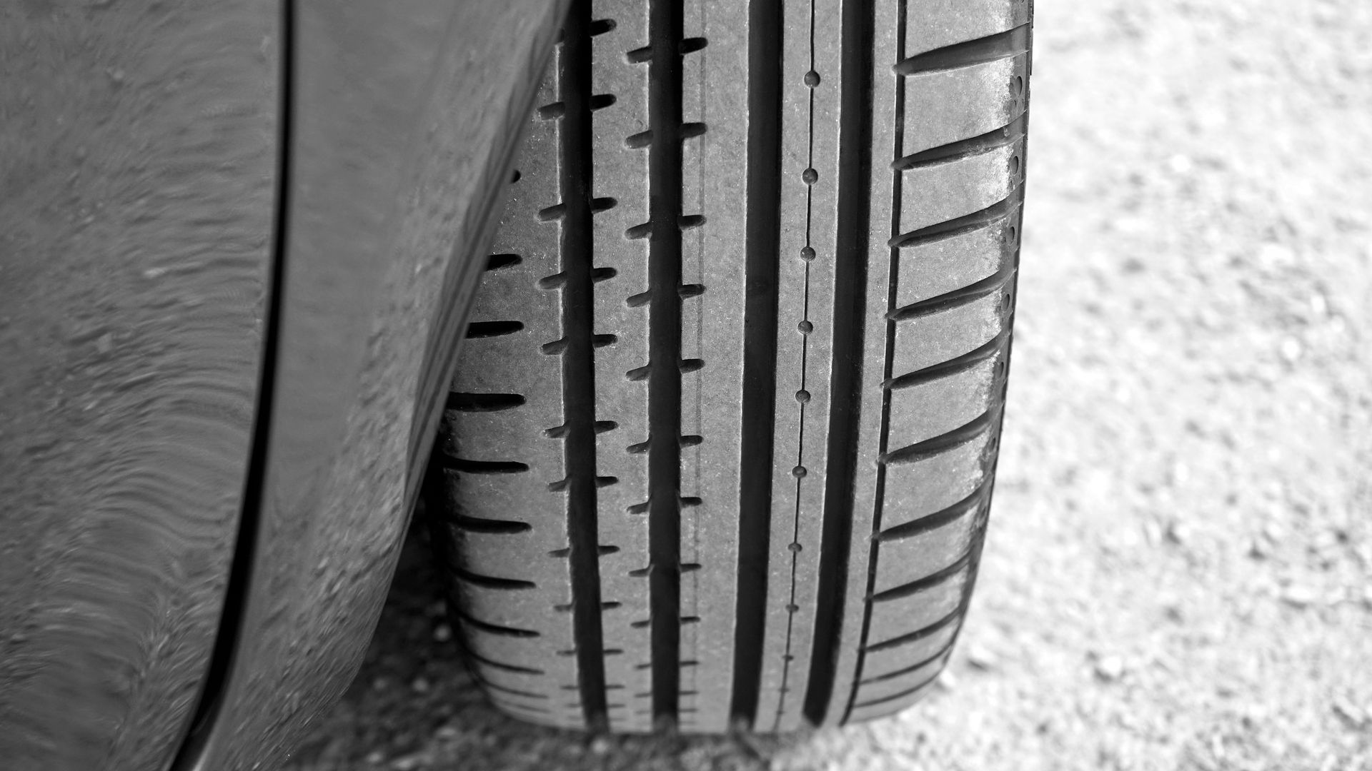 Close-up of an off-road truck tire tread resting on gravel